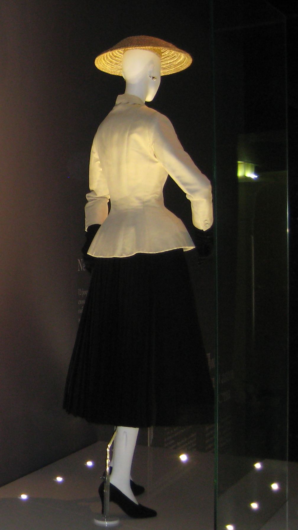 Another example of the 1947 Dior Bar suit with a wide-brimmed black hat displayed in an exhibition