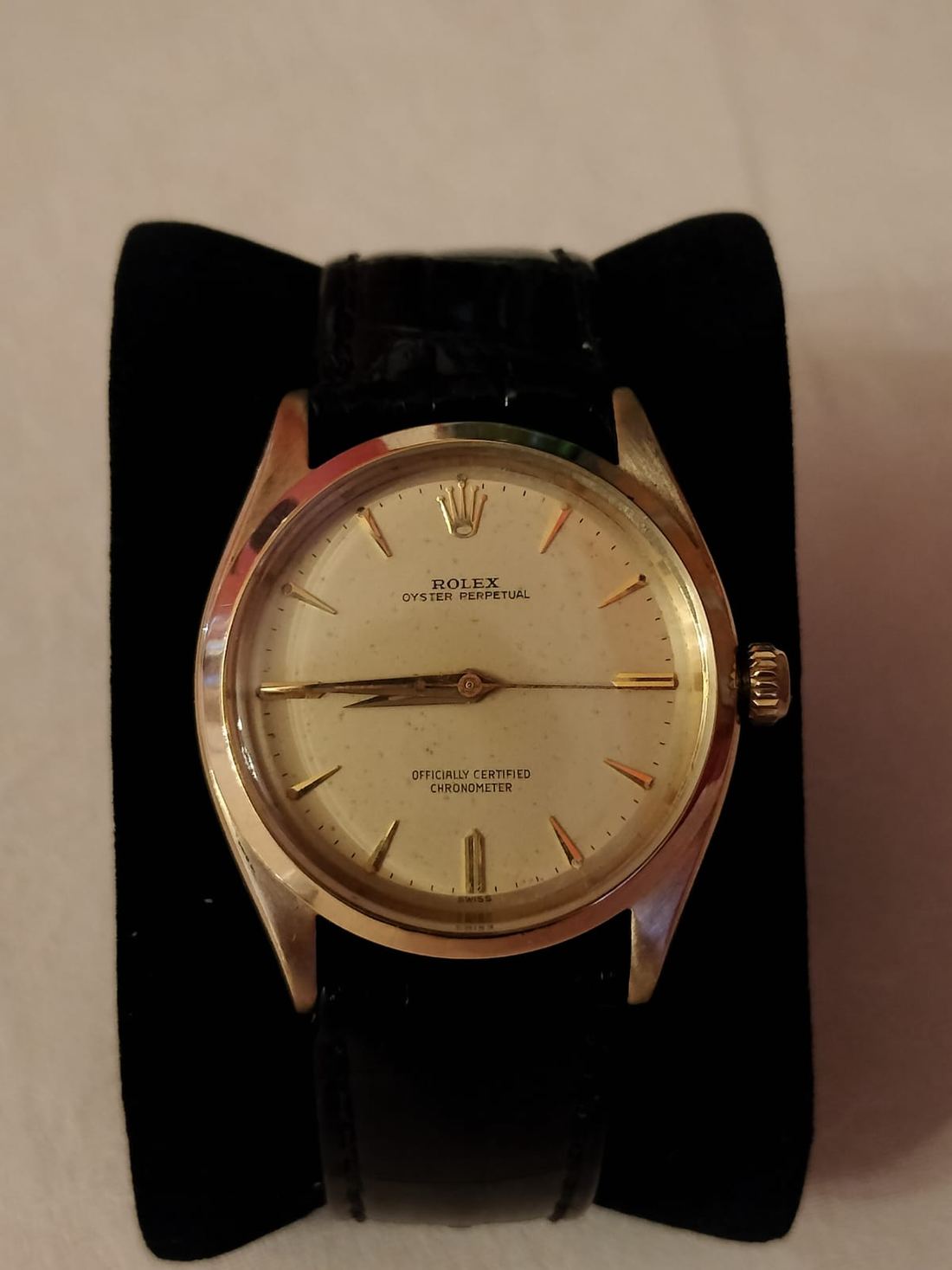 A gold Rolex Oyster Perpetual from the late 1950s on a black leather strap