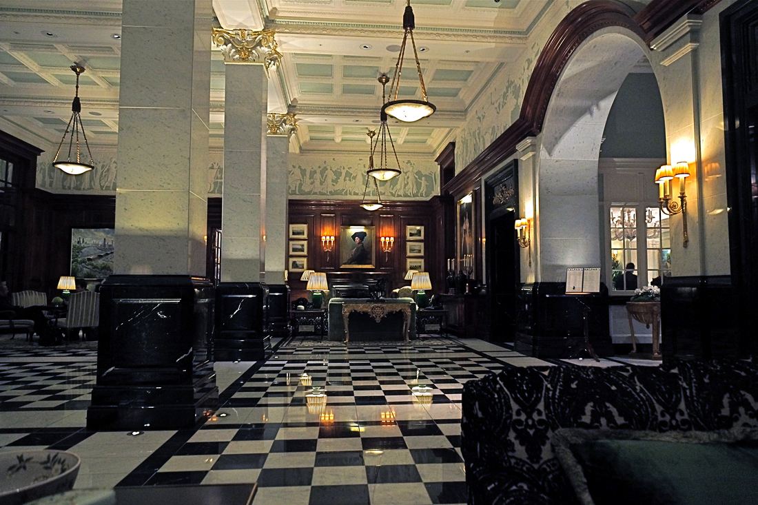 The Savoy hotel foyer with a black and white chequered floor and dark wood panelling
